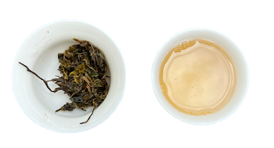 A gaiwan and a teacup with tea leaves and liquid respectively